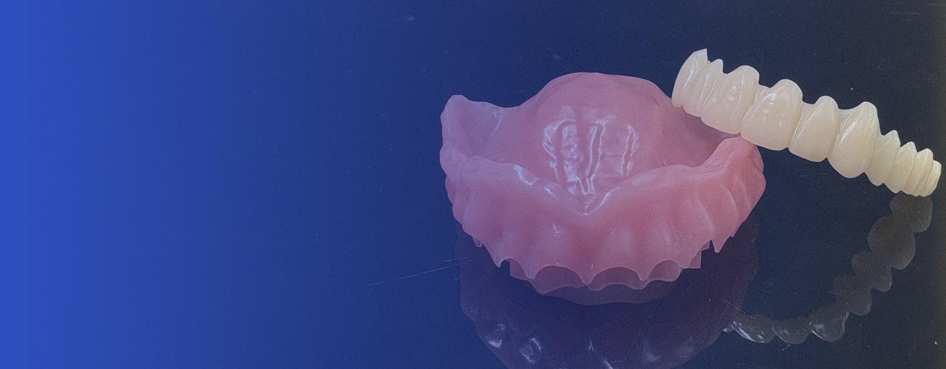 Milled full denture and tooth-shade PMMA on a reflective surface